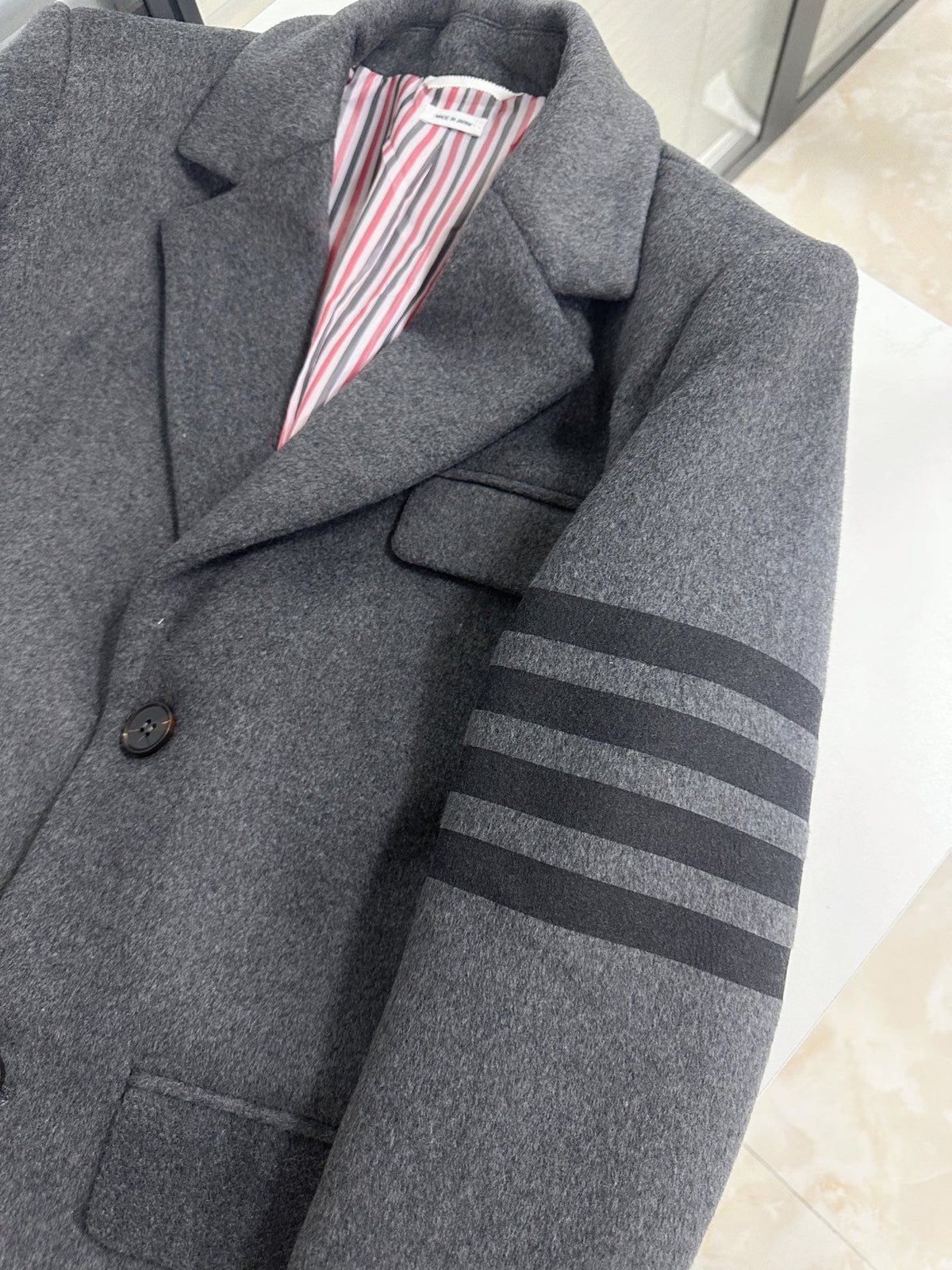 Unisex long wool coat by Thom Browne, outerwear detail view
